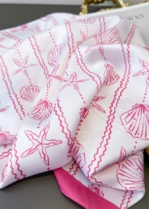 Detail of silk scarf with sea shell prints, pink starfish patterns and glossy texture