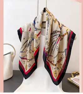 Détail d'un foulard en soie vintage aux motifs équestres avec bordures rouge et noir