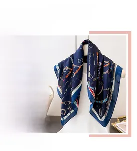 Détail d'un foulard en soie avec motifs de ceintures équestres vintage et chaînes