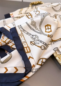 Gros plan d'un foulard en soie avec motif équestre vintage et texture lisse de luxe