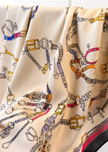 Détail d'un foulard carré en soie avec motifs équestres de ceintures et chaînes vintage