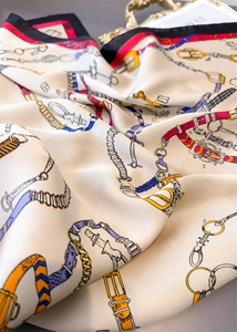 Détail d'un foulard en soie vintage à imprimé équestre avec motifs mors et chaînes