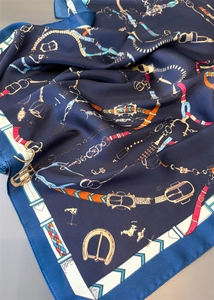 Vue détaillée des motifs équestres vintage sur le tissu en soie bleu marine de l'écharpe