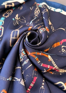 Détail d'un foulard en soie vintage avec motifs équestres et boucles en spirale