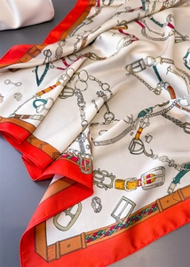 Détails d'un foulard en soie vintage au motif équestre avec des harnais et une bordure rouge