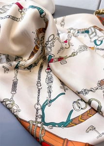 Détail du foulard en soie avec motif équestre et texture satinée élégante