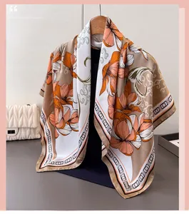 Detail of silk-satin floral scarf with elegant orange flower print on wooden hanger