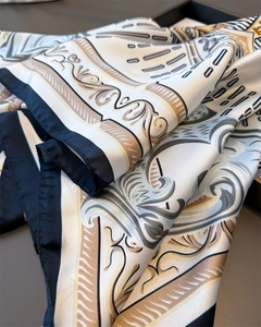 Detail of satin scarf featuring classic baroque patterns with blue and gold floral motifs