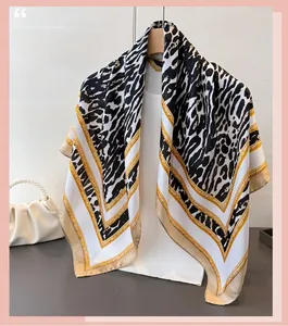 Detail of satin silk scarf with leopard print and golden chain pattern on a hanger