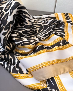 Detail of satin silk scarf with vintage leopard print and golden chain pattern