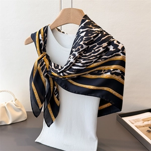 Elegant satin square scarf with leopard print and golden chain patterns on a mannequin