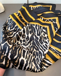 Detail view of luxury satin scarf with gold chain and leopard print patterns