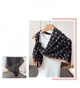 Detail of elegant silk scarf featuring geometric polka dots and C-letter pattern textures