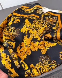 Détail d'un foulard en satin de soie de luxe avec motif baroque doré et créatures mythiques