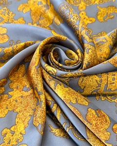 Détail d'un foulard en satin soyeux avec imprimés baroques dorés et texture grise