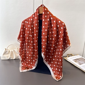 Detail of red silk scarf with white polka dots hanging elegantly on a wooden hanger