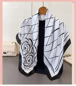 Detail of elegant satin floral scarf with black camellia pattern and grid design