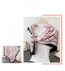 Detailed view of pink floral satin scarf with black geometric lines and camellia print