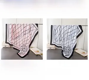 Detail of floral printed satin scarves in soft pink and white with classic check patterns