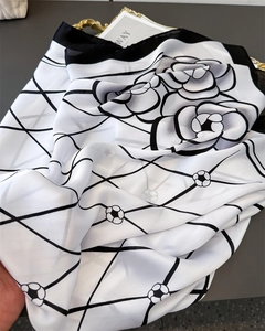 Detail of floral and grid print satin silk scarf with elegant drape and texture