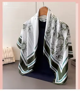 Détail d'un foulard carré en soie avec imprimé marguerite et bordure vert olive
