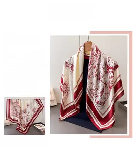Détail d'un foulard en satin de soie avec imprimé floral rouge et motifs marguerites
