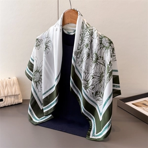 Foulard en satin de soie à motif marguerite vert olive sur un cintre en bois