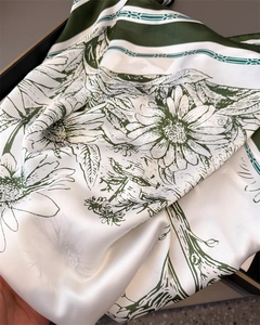 Détail de l'imprimé marguerite sur foulard en satin vert foncé à texture soyeuse fine