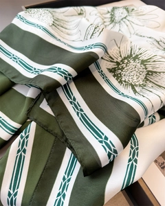 Vue détaillée du foulard en soie imprimé marguerites avec bordure cousue en vert foncé