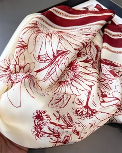 Texture détaillée du foulard en satin de soie avec imprimé floral marguerite et fini brillant