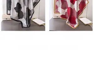 Detail of floral satin silk scarves in black and red draped over a quilted white bag