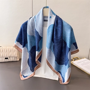 Detail of elegant blue and white floral satin silk scarf draped over a classic white top