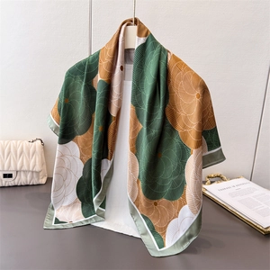 Detail of satin floral silk square scarf with geometric print draped on a hanger
