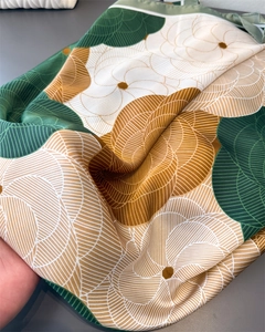 Detail of satin floral scarf with green and gold geometric patterns and silky texture