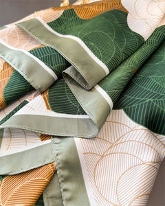 Detail of elegant green floral satin scarf showing smooth texture and fine rolled edges
