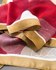 Close-up of geometric pattern silk scarf showing smooth texture and fine hemmed edges
