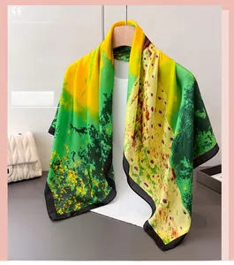 Detail of silk-like satin scarf featuring vibrant peacock feather print in green and yellow