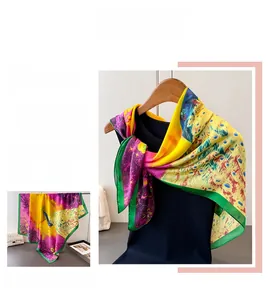 Detail of vibrant peacock feather print on large satin scarf with yellow and green colors
