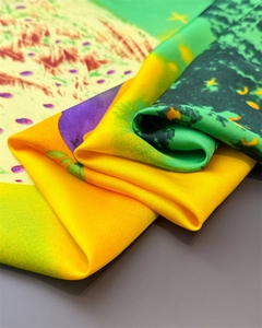 Close-up of elegant peacock satin scarf showing intricate print and silky texture