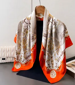 Close-up of luxury satin silk scarf with vintage gold chain and floral patterns