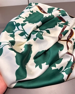Nahaufnahme von Satin-Halstuch mit grünen Blumenmustern und Beauty-Schriftzug