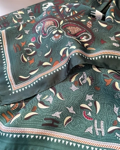 Macro detail of dark green satin scarf with paisley pattern and silk texture sheen