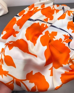 Nahaufnahme von Satin-Halstuch mit orangefarbenem Blumenmuster und Beauty-Textband