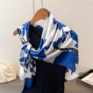 Detailansicht eines Seidenschals mit blauen Blumenmotiven und Beauty-Schriftzug