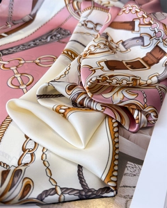 Detailed macro shot of luxury chain print and satin texture on a square silk scarf