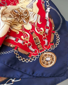 Detail of luxury silk scarf showing golden chain prints and equestrian motifs