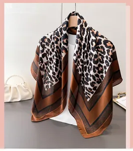Détail d'un foulard en soie à imprimé léopard, texture drapée sur un cintre en bois