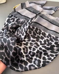 Détail d'un foulard en soie avec imprimé léopard noir, blanc et gris à motifs rayés