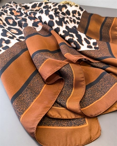 Détail d'un foulard en soie léopard montrant la texture satinée et les bords ourlés