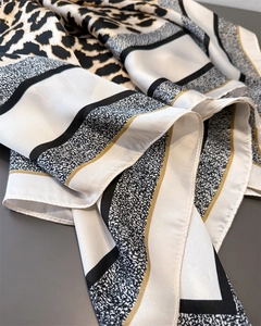 Gros plan du foulard en satin à imprimé léopard avec rayures géométriques et texture soyeuse